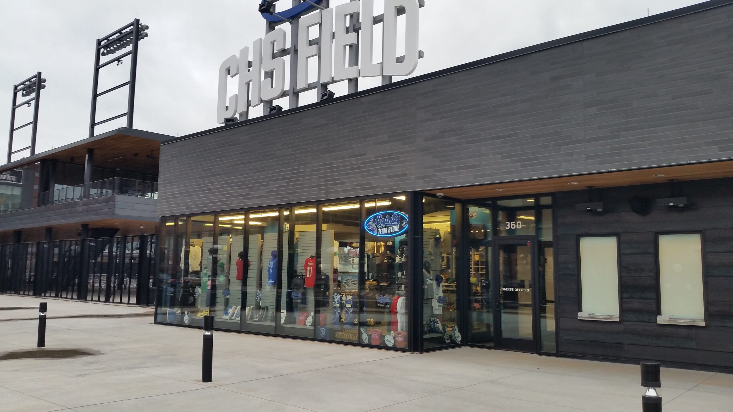 Exterior view of a modern storefront with large gray 'CHICAGO' sign and glass windows displaying sports jerseys and merchandise